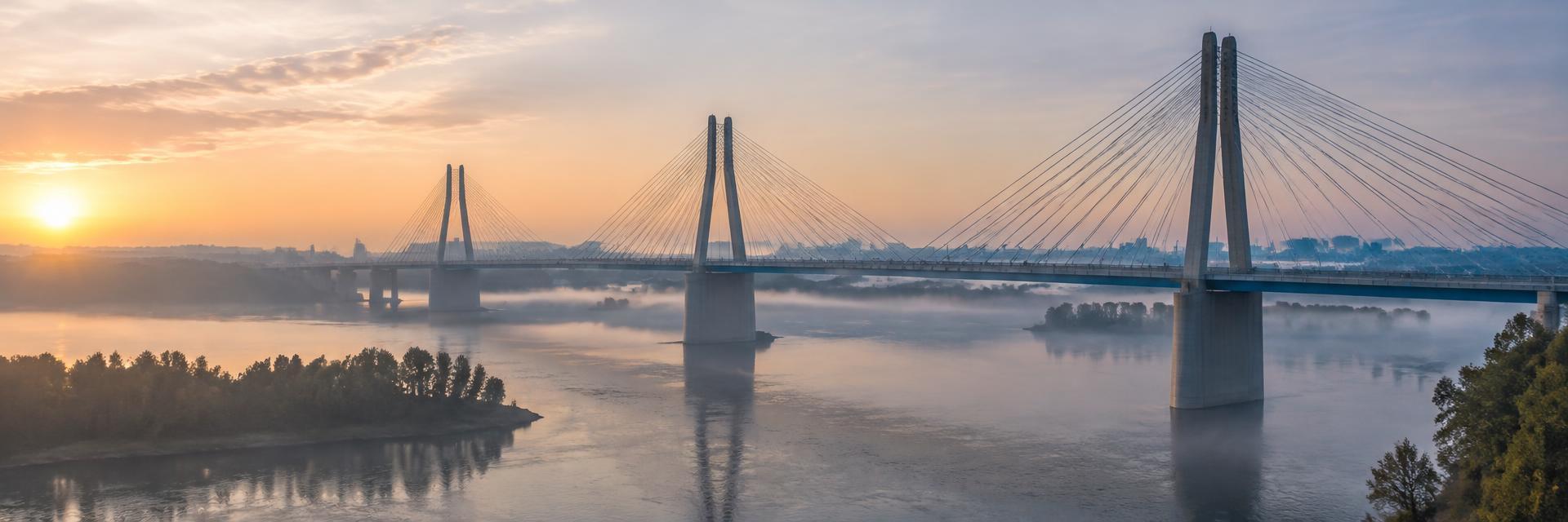 Illustrative image: modern cable-stayed river bridge at dawn